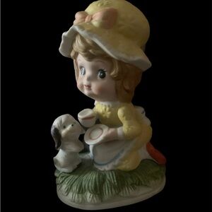 Vintage Girl Wearing Yellow Dress and Bonnet Feeding Puppy .